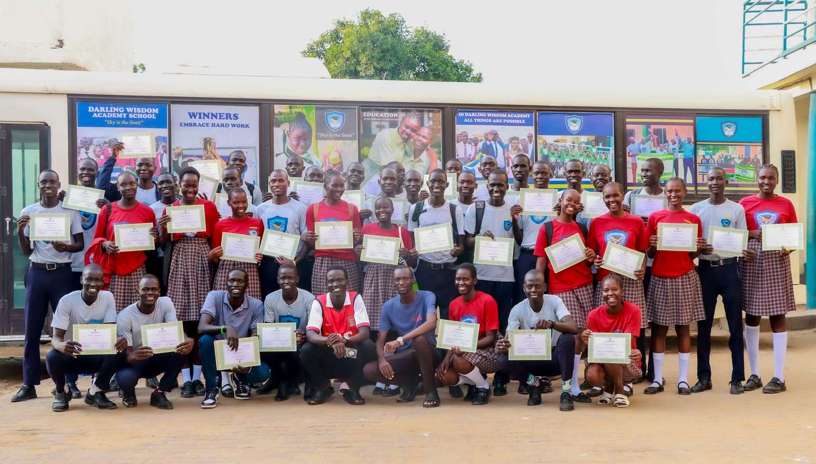 A large group holding certificates after a programme