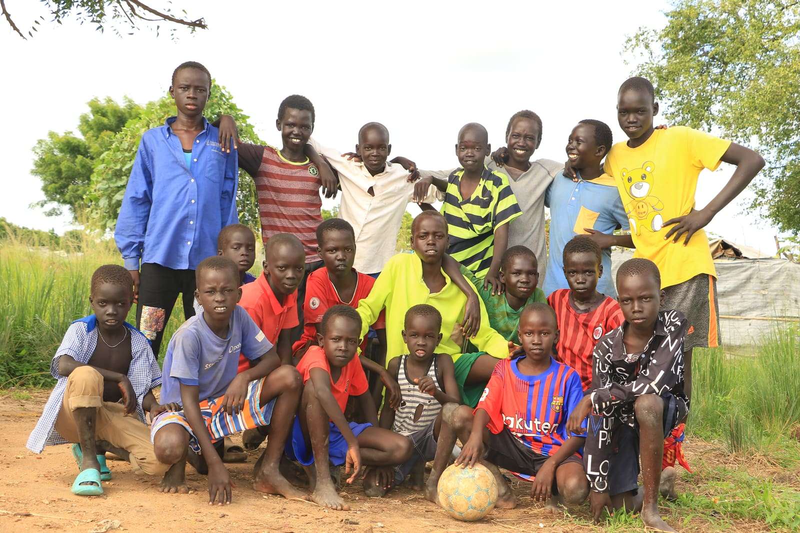 A large group of young footballers posing together with their ball