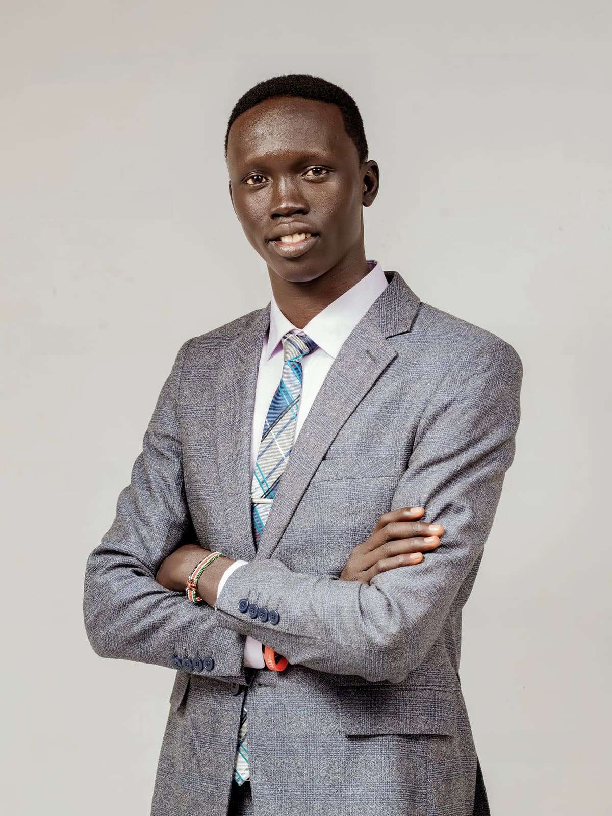 Kur Peter Thon Aduot, founder of Peace Across Generations, in a grey suit