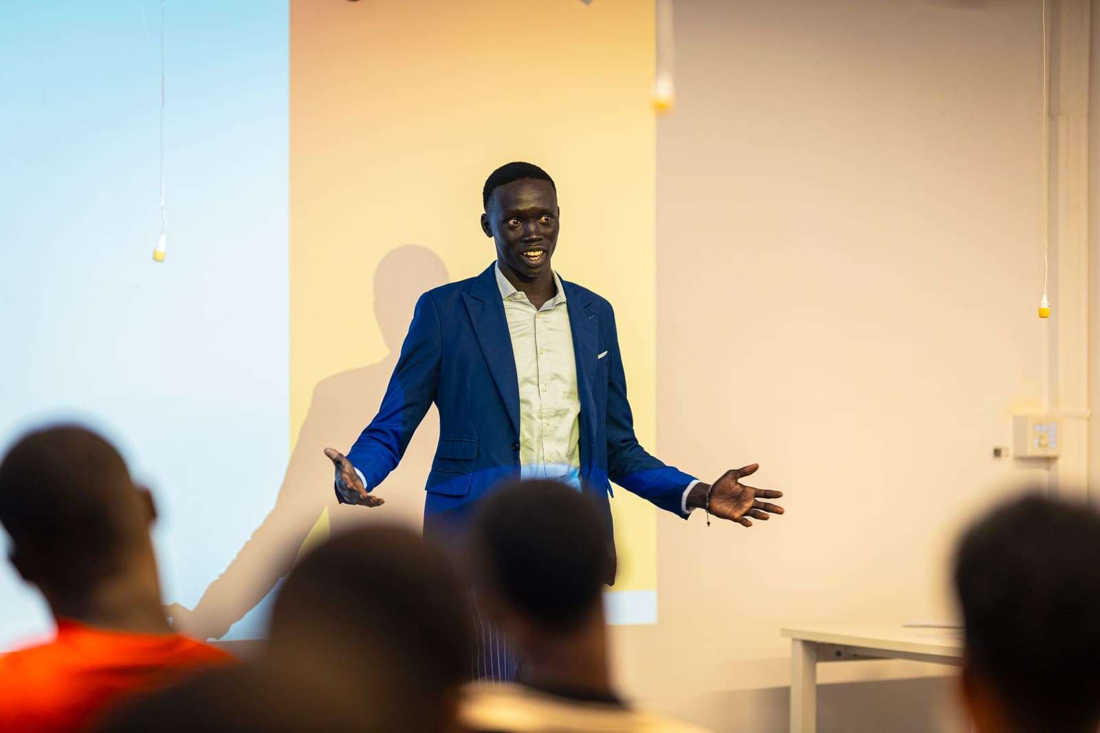 The founder speaking to a room of young people